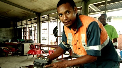 Young man in vocational workplace gaining skills